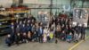 The entire workforce of the plant in Poland stands with members of the Schmid family between two wood-burning furnaces.